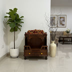 Small wooden altar with decorative items in a room with a plant and a vase.
